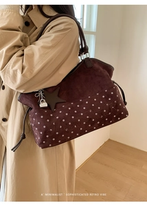 Detail of burgundy suede tote bag featuring polka dots, Moon Shark embroidery and star charm