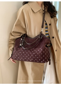 Detail of dark brown suede tote bag with polka dots, Moon Shark embroidery, and star charm