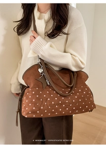Detail of brown suede tote bag with white polka dots, embroidery and star charms
