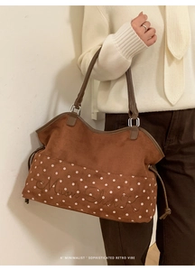 Close-up of brown suede tote bag with white polka dots and Moon Shark embroidery detail
