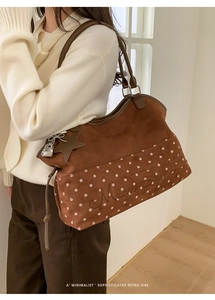 Detail of retro brown suede tote bag featuring white polka dots and Muon Share embroidery