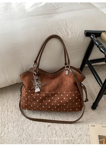 Close-up of brown suede tote bag featuring white polka dots and Moon Shark embroidery
