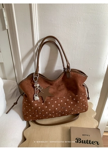Detail of brown tote bag with white polka dots, star charm, and Moon Shark embroidery
