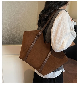 Side view of large dark brown suede tote bag worn by model for retro commute style
