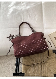 Detail of burgundy tote bag featuring white polka dots and Moon Shark embroidery