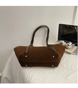Detailed view of the brown suede tote bag bottom with protective silver metal studs