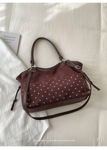 Detail view of brown polka dot suede tote bag with drawstring and shoulder strap