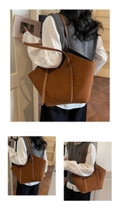 Detail view of large brown suede tote bag with slim shoulder straps and drawstring accents