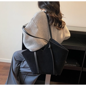 Detail view of the black oversized tote bag showing matte texture and unique V-cut design