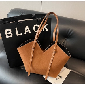 Detailed close-up of brown suede tote bag with V-cut opening and knotted handle design