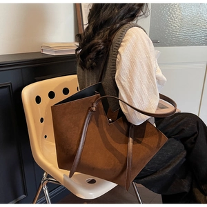 Detail of dark brown faux suede tote bag featuring unique V-shaped geometric cut edges