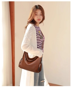 Detailed view of a brown pebbled leather hobo bag with gold zippers and crossbody strap