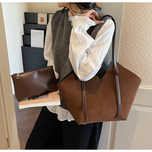 Detail of vintage brown suede tote bag featuring internal pouch and V-shaped top cut