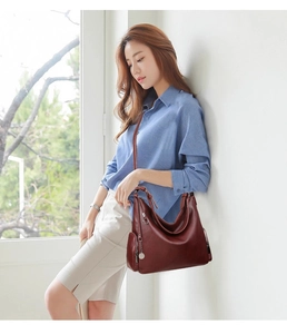 Detail of burgundy hobo bag with pebble leather texture and side zipper pocket