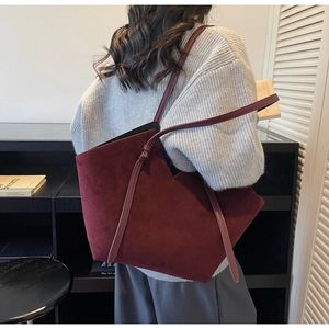 Detail of burgundy suede tote bag featuring unique geometric cut and knot strap detail