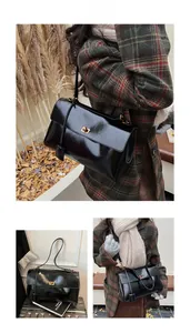 Detail view of black glossy shoulder bag with gold turn-lock and autumn aesthetic elements