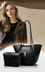 Dettaglio del set borsa a tracolla intrecciata nera con fibbia dorata e pochette abbinata