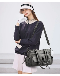 Sac fourre-tout gris foncé à poches multiples porté par un mannequin dans un style urbain