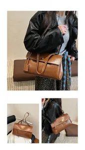Macro detail of brown leather Kelly bag with gold buckle and textured finish