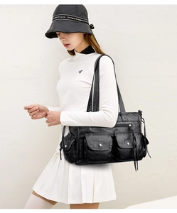 Détail du sac cabas en cuir noir vintage avec plusieurs poches et fermetures argentées