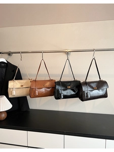 Close-up of vintage leather shoulder bags with gold square lock and side leather tags