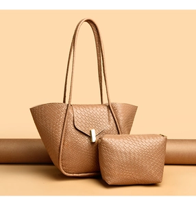 Dettaglio della borsa tote marrone intrecciata e pochette con chiusura in metallo oro