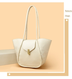 Dettaglio della borsa tote beige intrecciata con classica fibbia rettangolare in metallo dorato