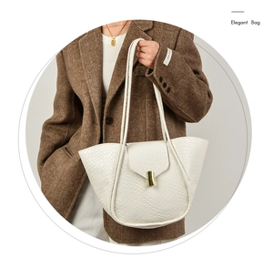 Dettaglio della borsa a tracolla in pelle intrecciata bianca con chiusura dorata