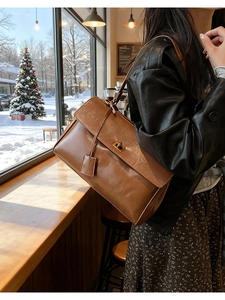 Detailed view of the large brown vintage leather shoulder bag with a metal turn-lock closure