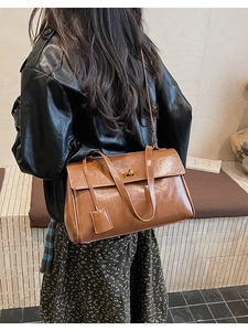 Macro detail of glossy brown leather tote bag with metallic turn-lock and handles