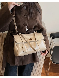 Detail of metallic gold shoulder bag with pleated texture and golden twist lock closure