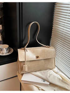 Detail of milk tea color faux wax leather shoulder bag with gold rotary lock on flap