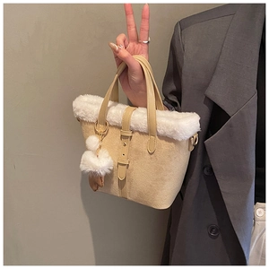 Detail of beige faux suede tote bag with white fleece trim and decorative strap buckle
