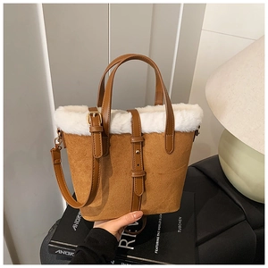 Detail of winter bucket bag with brown suede material and white faux fur trim