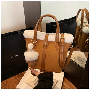 Detail of brown faux suede bucket bag with white faux fur trim and plush heart charm
