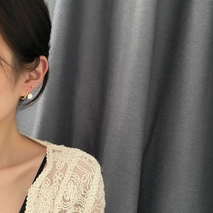 Elegant gold hoop earrings with white flower charms on a model for a chic Korean aesthetic