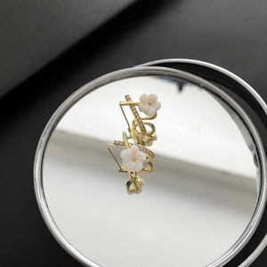 Elegant gold flower stud earrings with shell petals and shimmering cubic zirconia stones