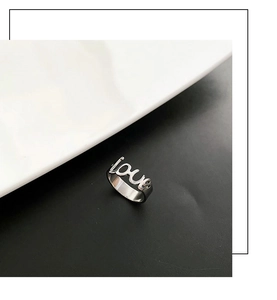 Dettaglio dell'anello in acciaio inossidabile argento con scritta LOVE traforata