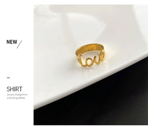 Vista dettagliata di un anello dorato traforato con scritta Love su un piatto di ceramica