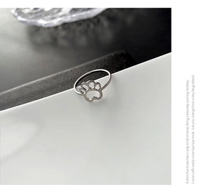 Macro detail of silver stainless steel ring featuring a hollow cat paw print design