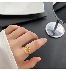 Close-up of a gold cat paw cutout ring in titanium steel on a woman's finger