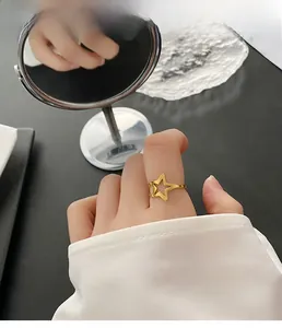 Detailed close-up of a hollow star-shaped gold titanium steel ring worn on a finger