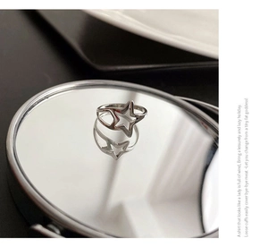 Macro view of minimalist hollow star stainless steel ring reflected on a round mirror