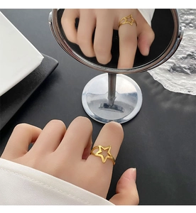 Macro shot of minimalist gold hollow star ring with reflective mirror surface details
