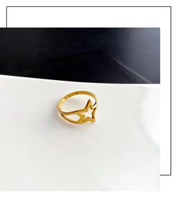 Macro shot of minimalist hollow star ring in gold finish on modern white display