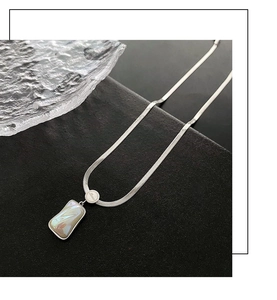 Detailed macro view of silver snake chain with rectangular mother of pearl pendant inlay