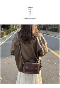 Detail of color-block brown crossbody bag with leather texture in outdoor sunlight