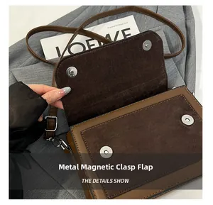 Detail of color-block handbag with dual magnetic buckles and soft suede lining