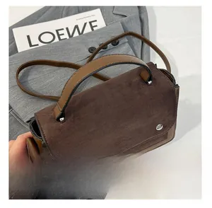 Detail of contrast stitch handbag with matte finish and silver round metal fastener