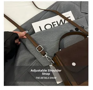 Detail of adjustable shoulder strap and silver hardware on a contrast panel handbag